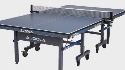Featured image of the JOOLA Tour 2500 indoor Table Tennis Table, highlighting its independent table halves with stable foldable steel legs, a dark blue 1-inch tabletop with UV-cured silk striping, and locking caster wheels for professional-grade play.